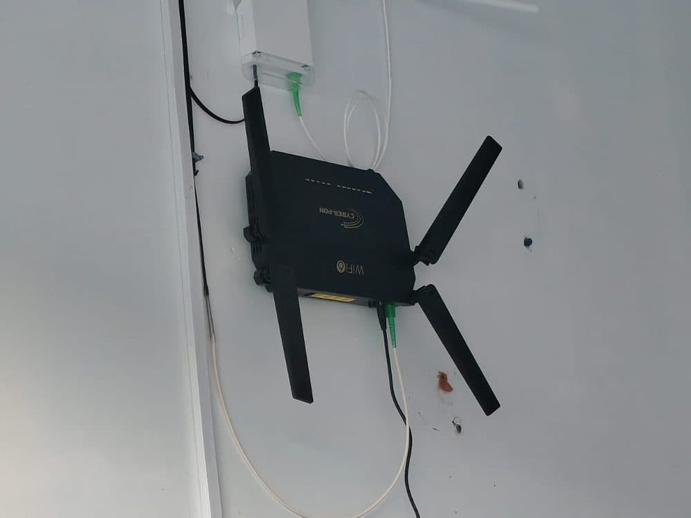 Repetidor WiFi instalado en pared junto al equipo de red del domicilio