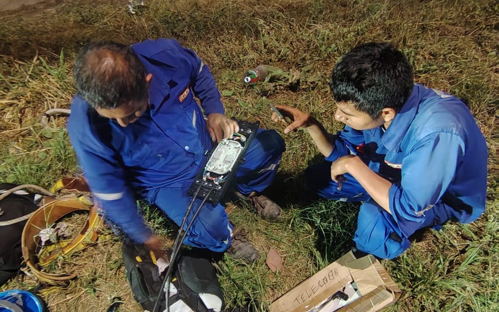 Dos técnicos de Shiro Telecom empalmando fibra óptica sobre el terreno