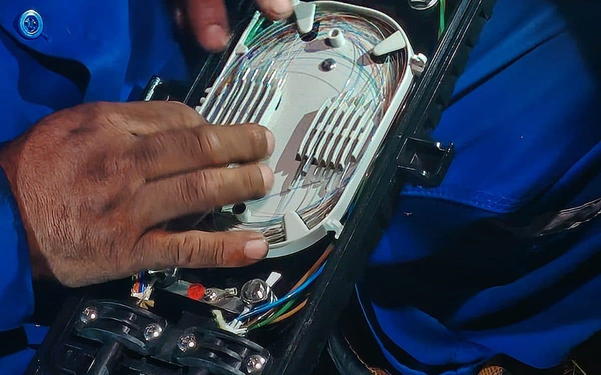 Técnico empalmando fibra óptica en una caja de distribución